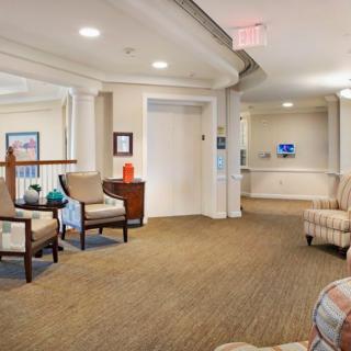 A comfortable and well-lit lobby area with armchairs and decorative plants.