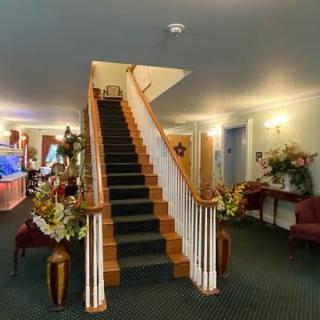 A well-decorated lobby featuring a central staircase with floral arrangements.