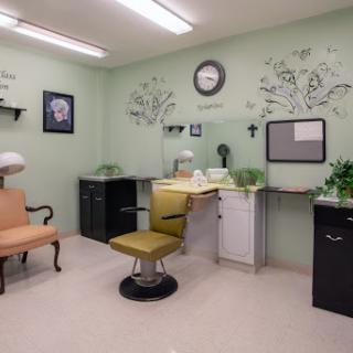 A serene salon space featuring a soft green ambiance and comfortable seating.