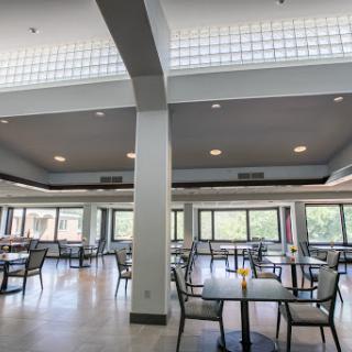 A bright and spacious dining area featuring modern furnishings and ample natural light.