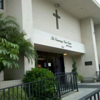 The entrance to a church building with a cross above the doorway.