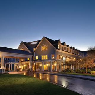 A well-lit hotel building at dusk with a grand entrance.