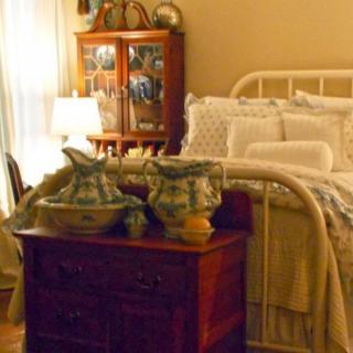 A vintage-style bedroom with antique furniture and decorative items.