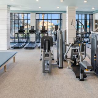 A modern gym with various exercise equipment, including treadmills and weight machines.