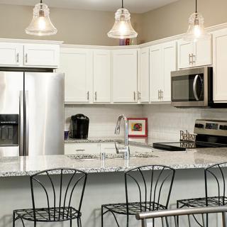 Modern kitchen with stainless steel appliances and stylish pendant lighting.
