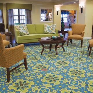 A cozy living room with colorful carpet and comfortable seating.