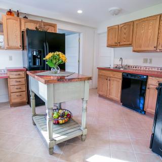 A modern kitchen with wooden cabinets, a central island, and contemporary appliances.