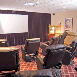 A cozy home theater setup featuring reclining chairs and a large screen for movie nights.