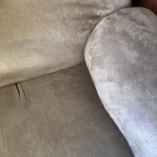 A close-up view of a fabric sofa with a cushion.