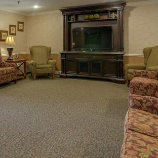 A cozy living room with comfortable seating and a television stand.
