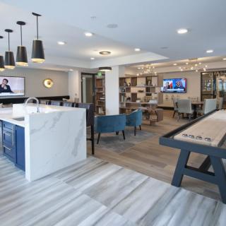 A modern open-concept living space featuring a kitchen, seating area, and entertainment section.