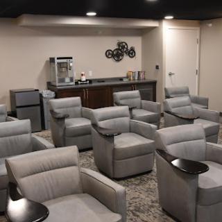 A cozy lounge area featuring modern chairs and a refreshment station, perfect for relaxation.