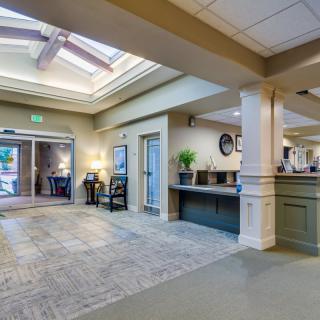 A spacious lobby area with a reception desk and entrance doors.