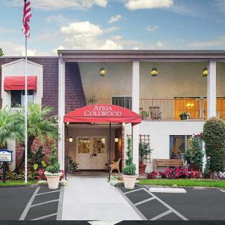 The exterior entrance of a hotel with red awnings and an American flag.