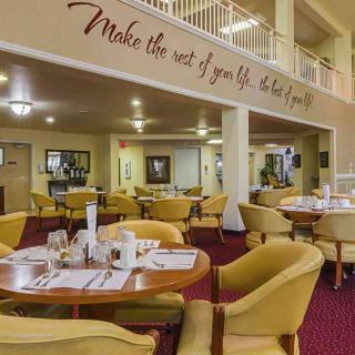 A cozy restaurant dining area with comfortable seating and a motivational quote on the wall.