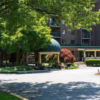 A hotel entrance surrounded by lush greenery and trees.