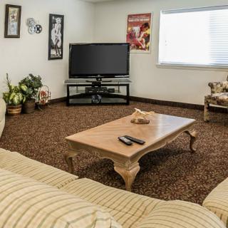 Cozy living room with a television, coffee table, and comfortable seating.