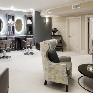 A modern salon interior with comfortable chairs and stylish mirrors.