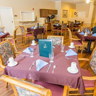 A neatly set dining area in a restaurant with elegantly arranged tables and chairs.