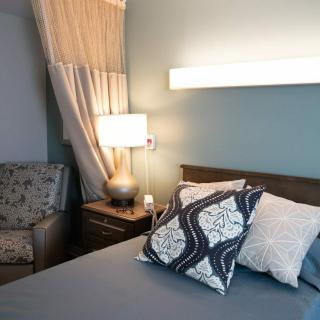 A cozy bedroom with soft lighting, decorative pillows, and modern furnishings.