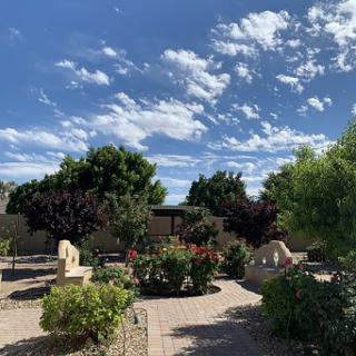 A beautifully landscaped garden under a partly cloudy sky.