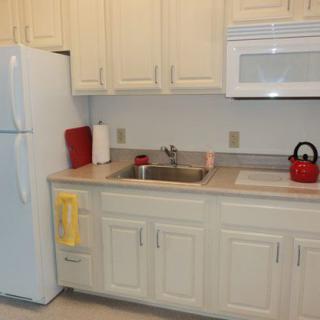 A small, well-organized kitchen with white cabinets and modern appliances.