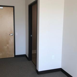 An empty room with two doors and plain walls.