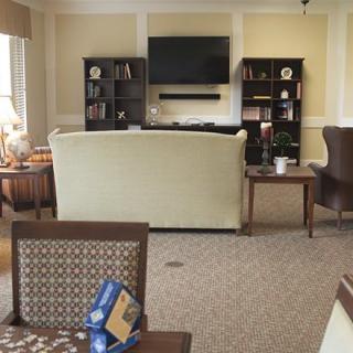 A cozy living room with a comfortable sofa, television, and well-organized bookshelves.