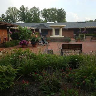 A serene outdoor space featuring a well-maintained garden and seating arrangements, inviting relaxation.