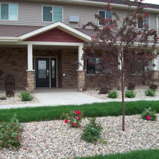 A well-maintained building entrance with neatly landscaped garden and pathway.