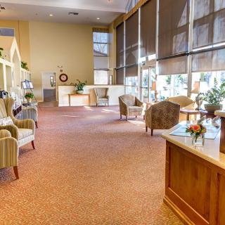 A spacious and well-lit lobby with comfortable seating and large windows.