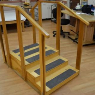A set of indoor rehabilitation stairs used for physical therapy exercises.