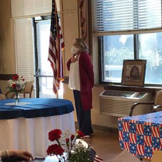 A ceremonial event where a speaker stands by the American flag.