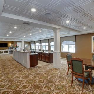 A spacious dining room with elegant furnishings and a carpeted floor.
