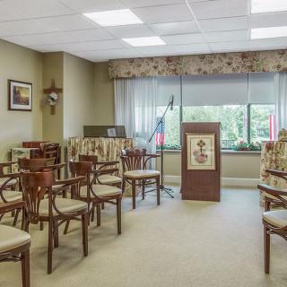 A well-lit conference room with multiple chairs and a podium, suitable for meetings or presentations.