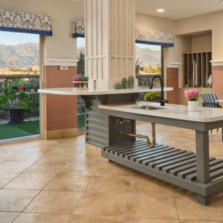 A modern kitchen interior featuring an island counter and ample natural light from large windows.