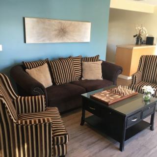 A cozy living room featuring a sofa and armchairs with striped upholstery, accented by a coffee table and modern decor.