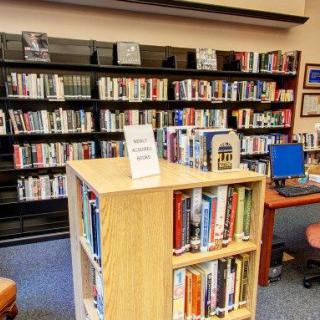 A cozy library section with shelves full of books and a reading area.