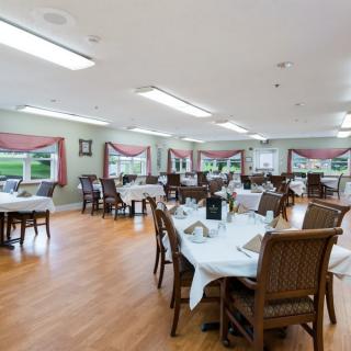 A spacious dining room with neatly arranged tables and chairs.