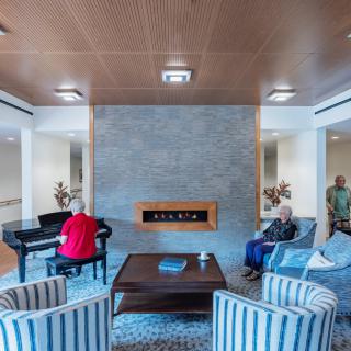 A modern living room with a grand piano, cozy seating area, and a stylish fireplace.