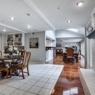 A modern dining room with elegant furniture and a blend of tiled and wood flooring.