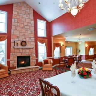 A spacious and elegant living room with a stone fireplace and a dining area.