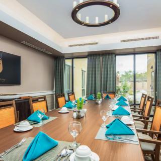 A modern and elegant dining room with a neatly set table, featuring blue napkins and stylish decor.