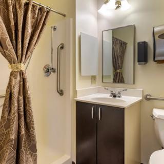 A modern bathroom featuring a shower, sink, and elegant curtains.