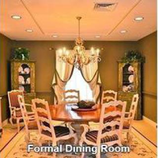 A formal dining room with a wooden dining table, chairs, and a chandelier.