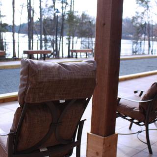 A serene patio with comfortable seating overlooking a lake and trees.