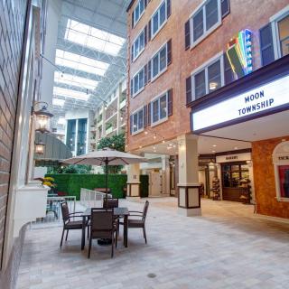 A modern indoor atrium with seating and natural light from skylights.