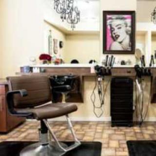 A stylish hair salon interior with a barber chair, mirrors, and chic decor.