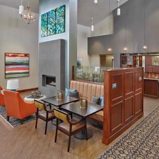 A modern and inviting lobby space featuring comfortable seating, a fireplace, and artistic decor.