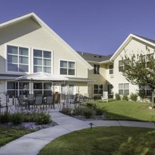 A modern residential building with a well-maintained garden and patio area.